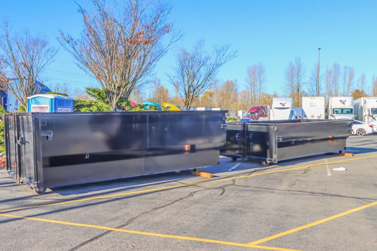 Professional dumpster rental service with roll-off container on residential driveway in Closter